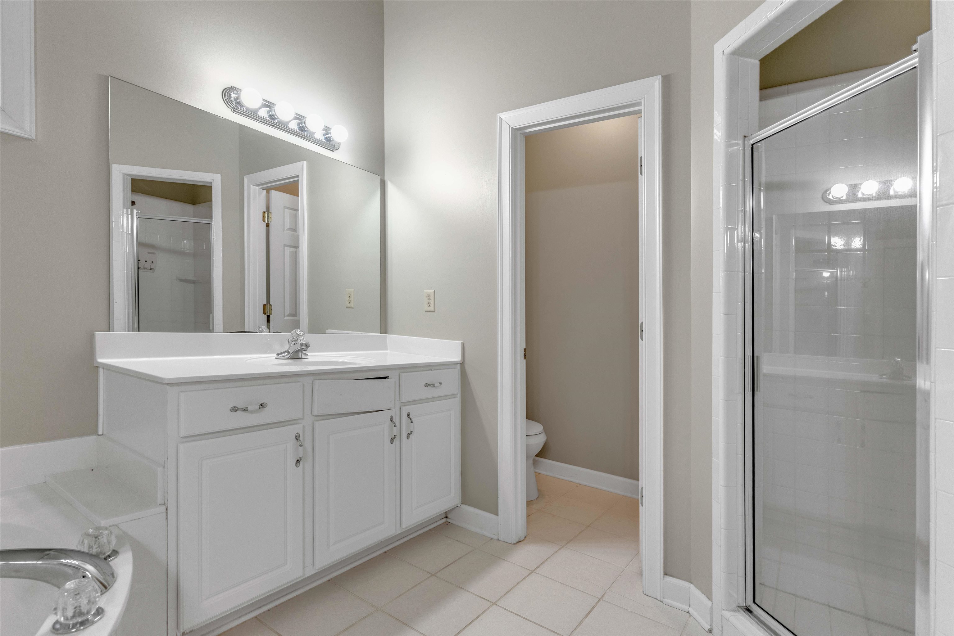1335 Riding Brook Drive Collierville, TN 38017 - Photo 15 of 32 Bathroom featuring light tile patterned floors, a shower stall, vanity, and a garden tub