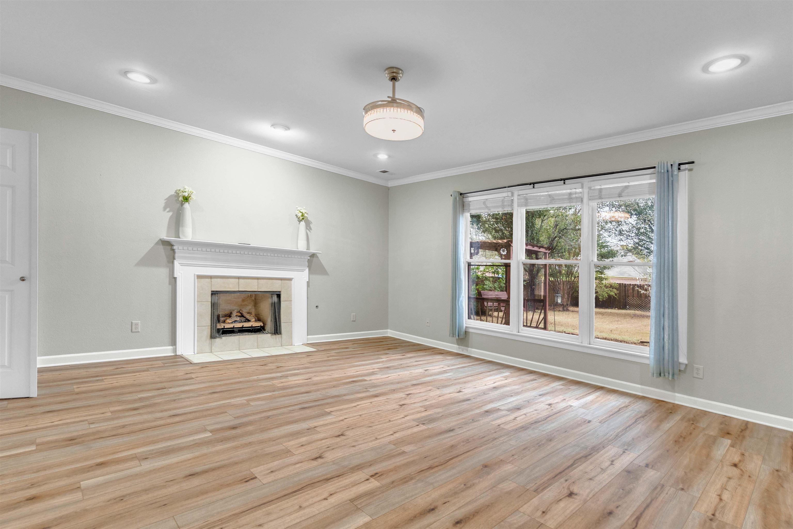 1335 Riding Brook Drive Collierville, TN 38017 - Photo 3 of 32 a view of an empty room with wooden floor fireplace and a window