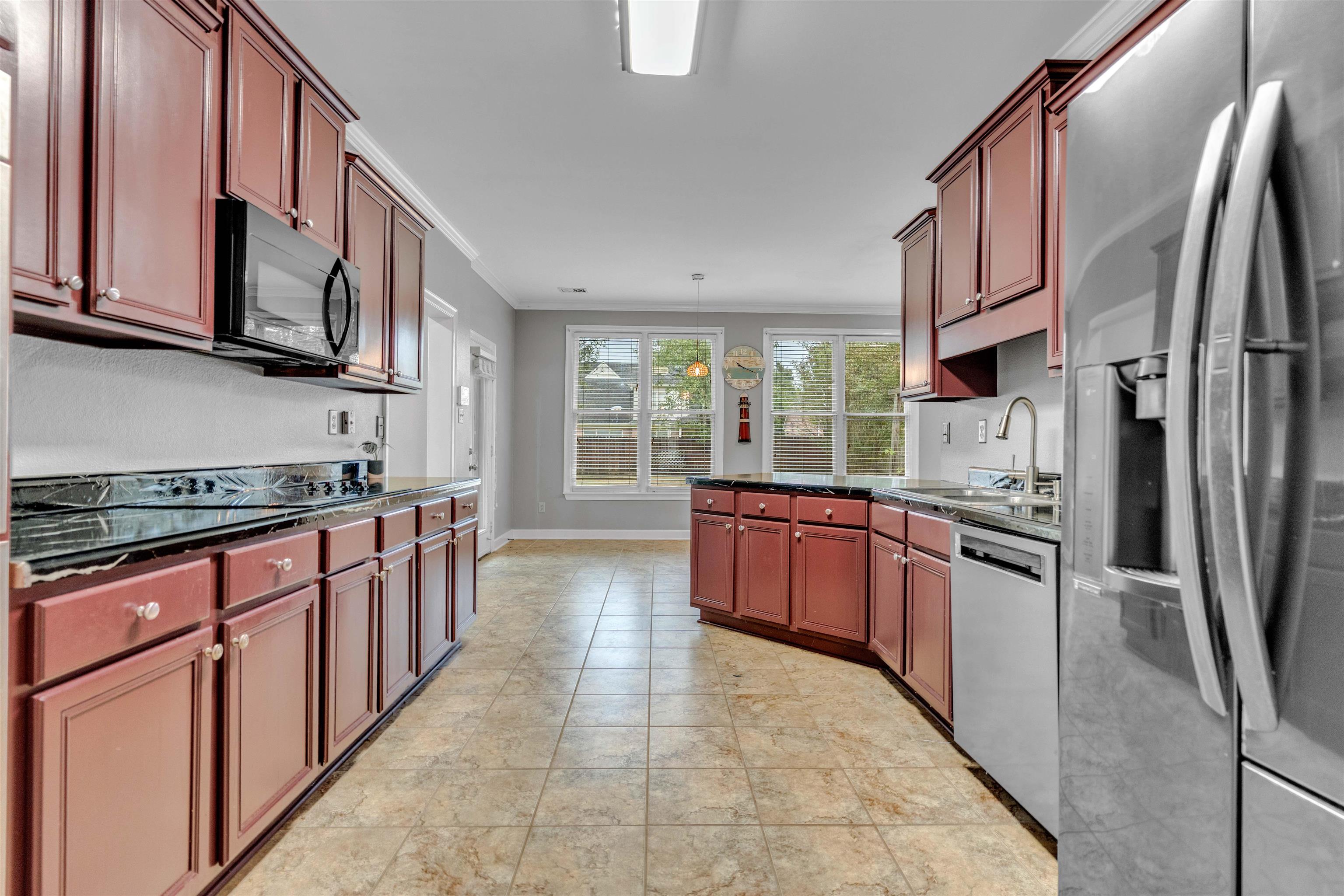 1335 Riding Brook Drive Collierville, TN 38017 - Photo 6 of 32 a kitchen with stainless steel appliances granite countertop a stove top oven a sink dishwasher a refrigerator and cabinets with wooden floor