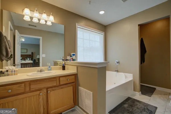 a bathroom with a sink mirror and a bathtub