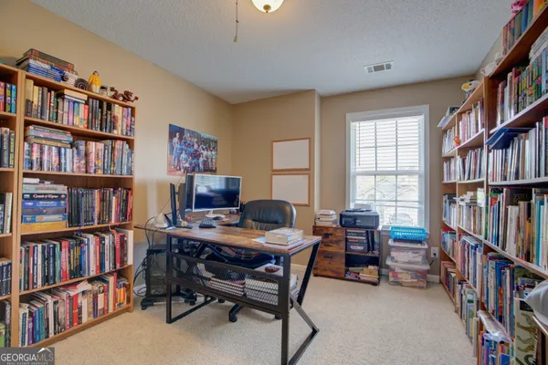 a view of a workspace with furniture and a bookshelf