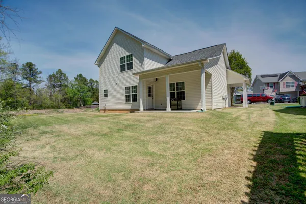 a view of a house with pool and yard