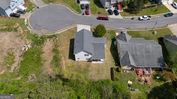 an aerial view of a house with a swimming pool and outdoor seating