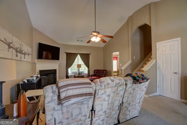 a living room with furniture a fireplace and a flat screen tv