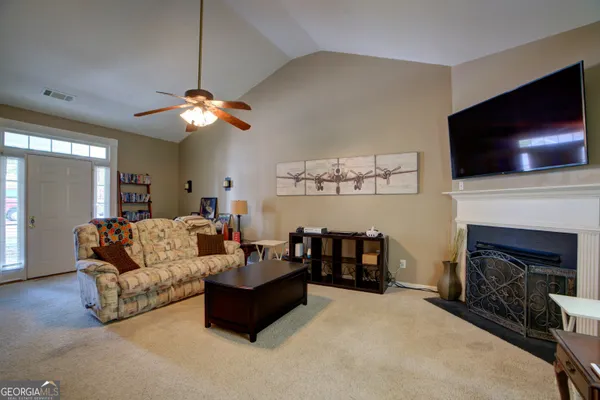 a living room with furniture a fireplace and a flat screen tv
