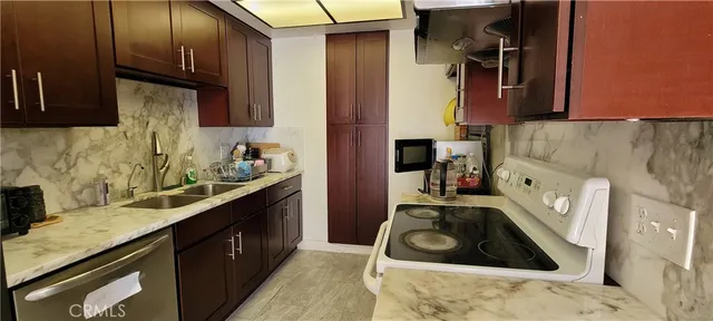 a kitchen with stainless steel appliances granite countertop a sink stove and cabinets