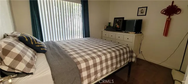 a bedroom with a bed tv and a window