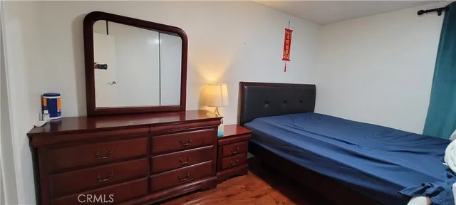 a bedroom with a bed and a mirror on dresser
