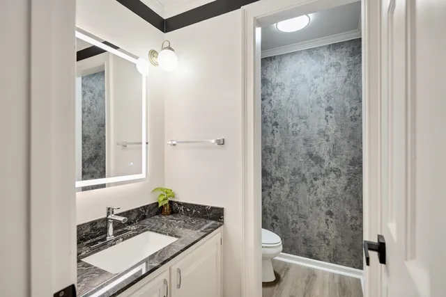 a bathroom with a granite countertop sink toilet and shower