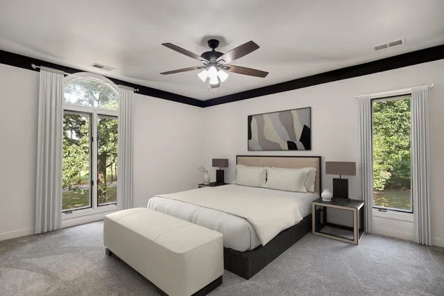 a bedroom with a large bed and a chandelier