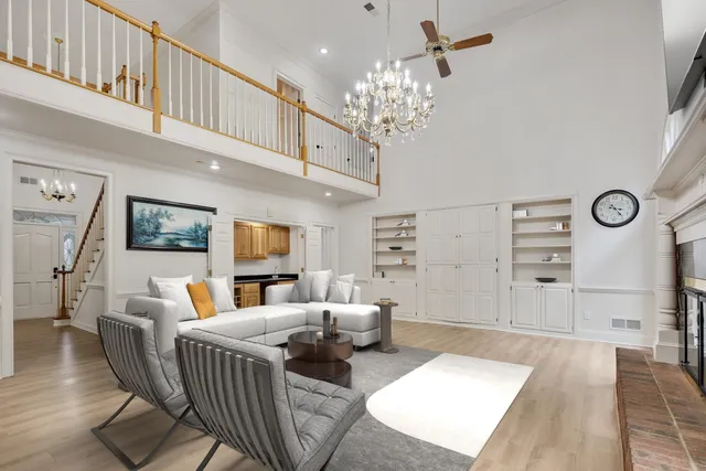 a living room with furniture a fireplace and a chandelier