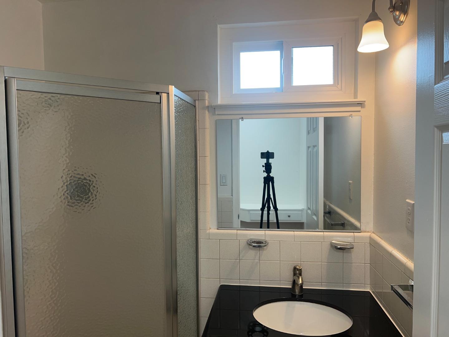 99 Castillejo Drive Daly City, CA 94015 - Photo 14 of 21 a bathroom with a sink a mirror a toilet and a window