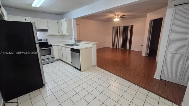 a kitchen with a refrigerator sink and cabinets