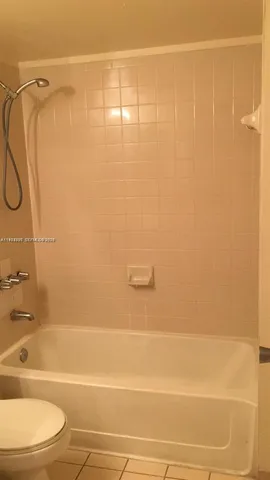 a bathroom with a shower and a white bath tub