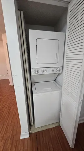 a utility room with wooden floor washer and dryer