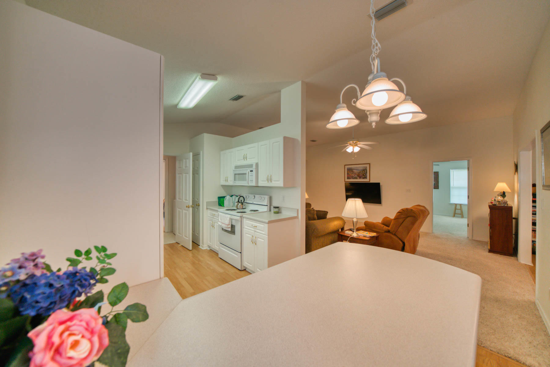 1755 Old Ranch Road Fort Walton Beach, FL 32547 - Photo 29 of 35 a large white kitchen with a refrigerator and a chandelier