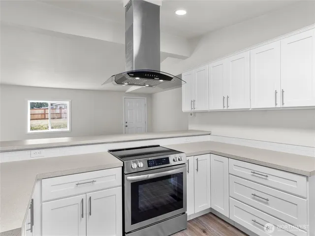 a kitchen with a stove and white cabinets