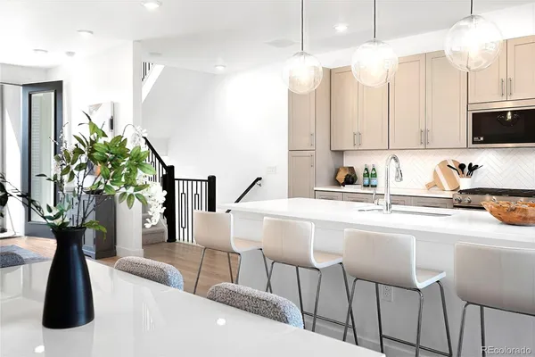 a kitchen with a table chairs refrigerator and microwave