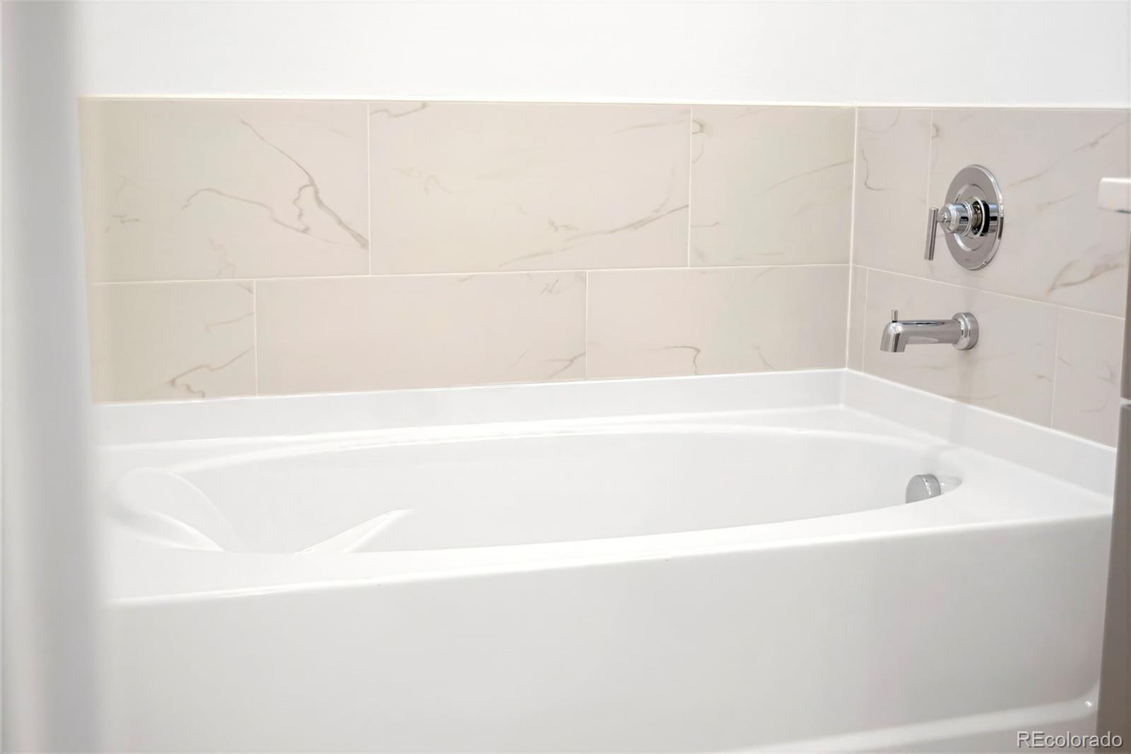 22 Oneida Court Denver, CO 80230 - Photo 12 of 44 a bathroom with a bathtub