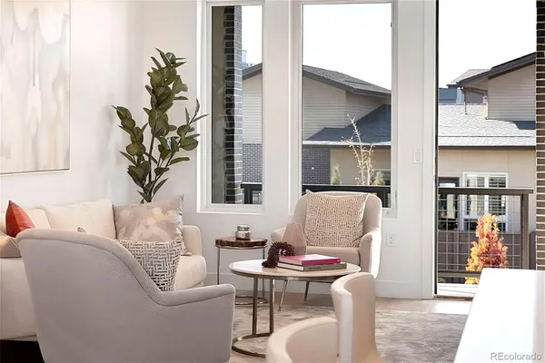 a living room with furniture a lamp and a potted plant