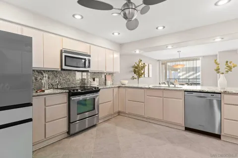 a kitchen with a sink stainless steel appliances and white cabinets