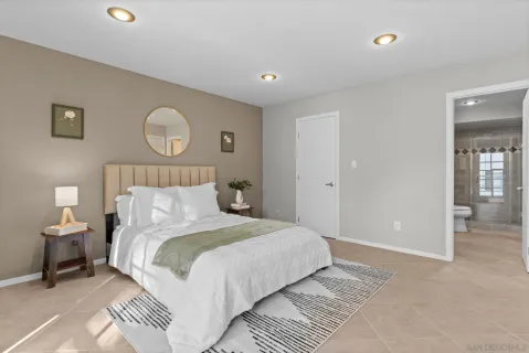 a bedroom with a large bed and a chandelier