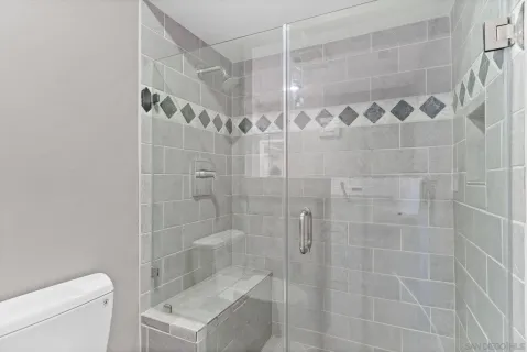 a bathroom with a granite countertop sink a mirror and a shower