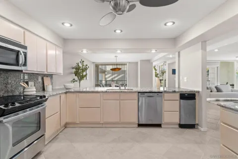 a kitchen with granite countertop appliances cabinets a sink and a counter top space