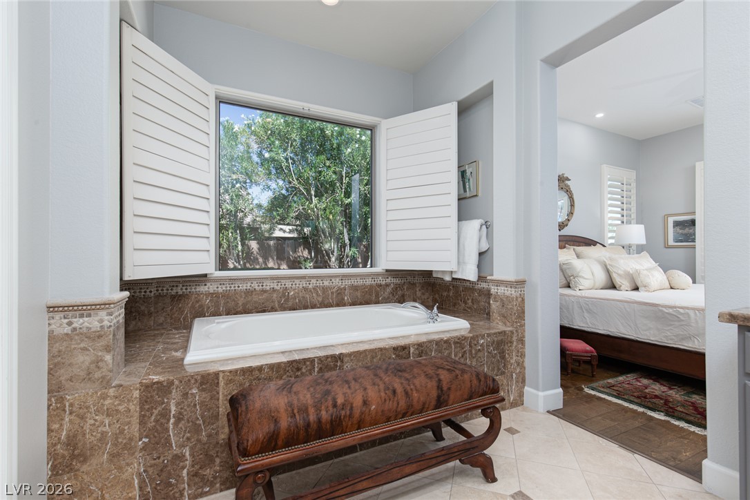 22 Douglas Grove Road Henderson, NV 89052 - Photo 37 of 72 Indulge in a relaxing soak within this primary bathroom featuring a deep tub with serene outdoor views.