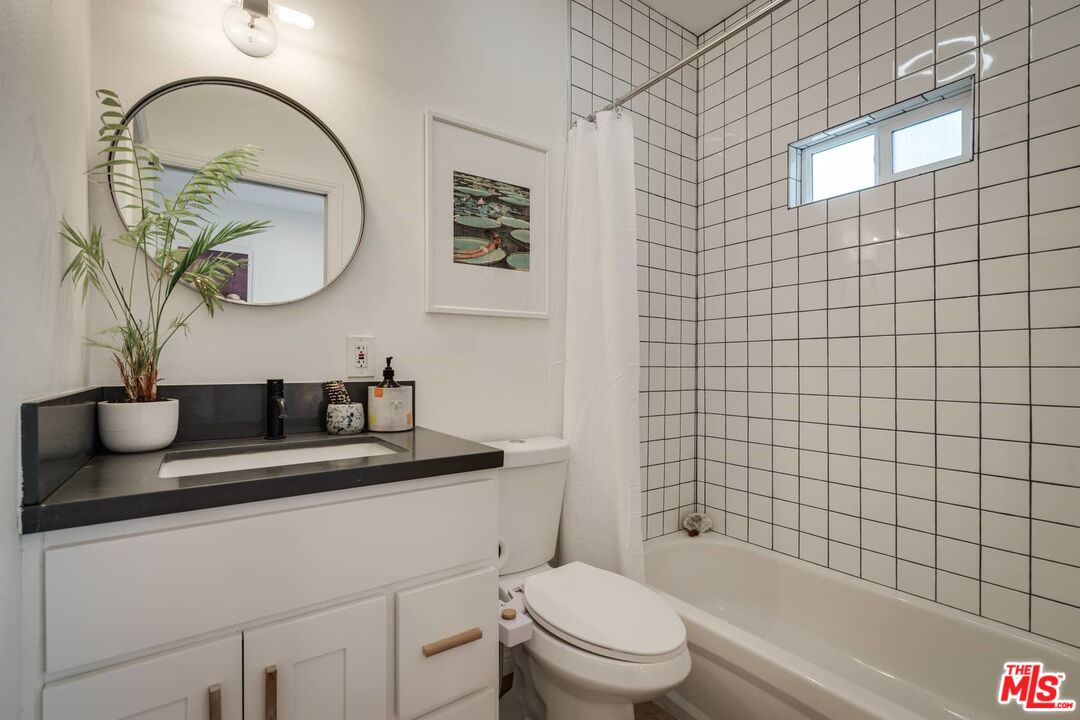 4535 Dudley Drive Los Angeles, CA 90032 - Photo 16 of 24 a bathroom with a granite countertop toilet a sink and mirror