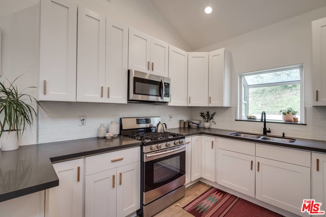 4535 Dudley Drive Los Angeles, CA 90032 - Photo 6 of 24 a kitchen with granite countertop white cabinets white appliances and a sink