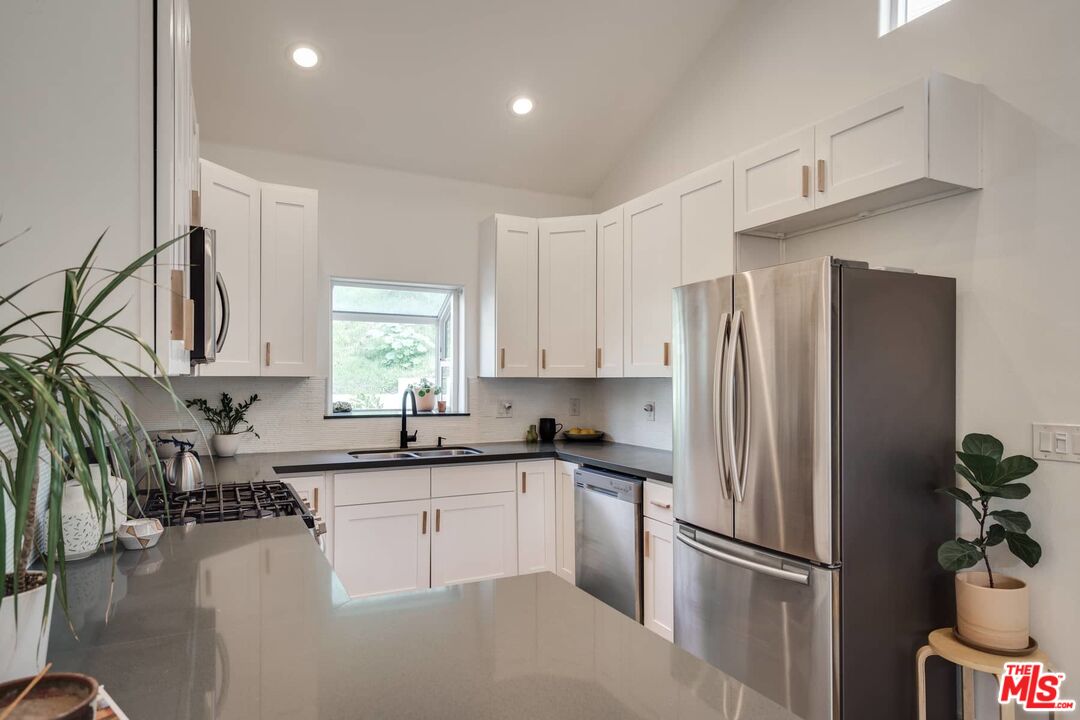 4535 Dudley Drive Los Angeles, CA 90032 - Photo 7 of 24 a kitchen with a refrigerator a sink and cabinets