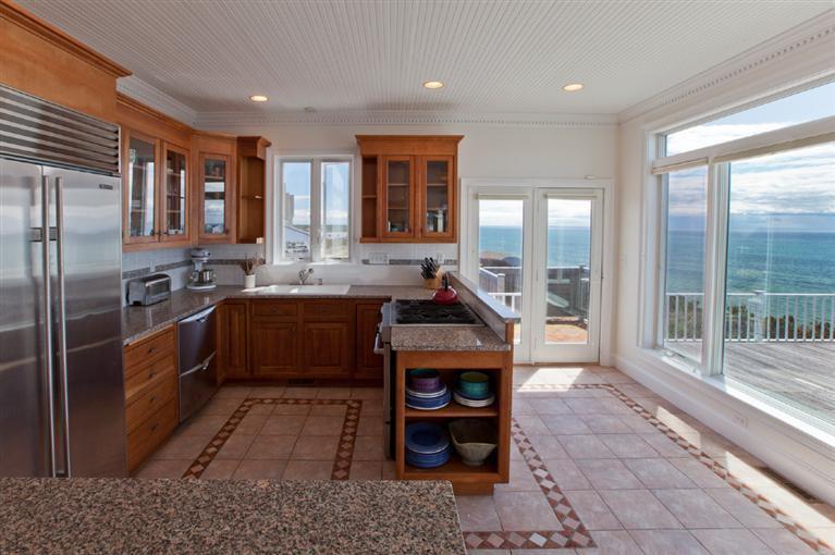 64 Corn Hill Road Truro, MA 02666 - Photo 9 of 30 a large kitchen with stainless steel appliances kitchen island granite countertop a large stove top oven and cabinets