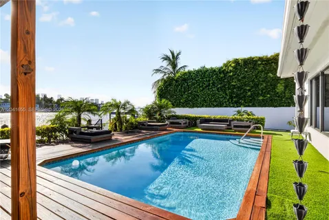 a view of a swimming pool with a patio and a garden