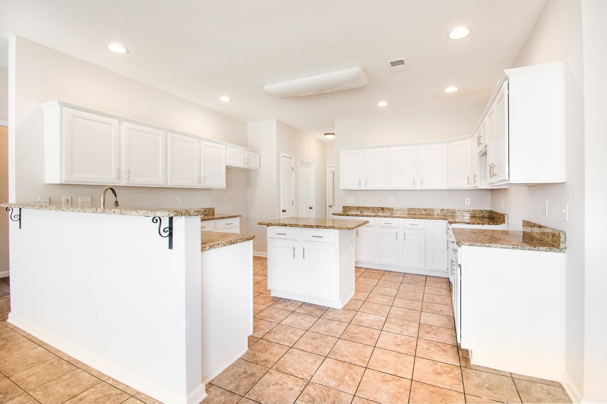 6024 Maher Trail Bartlett, TN 38135 - Photo 11 of 25 a kitchen with a refrigerator a stove top oven and white cabinets