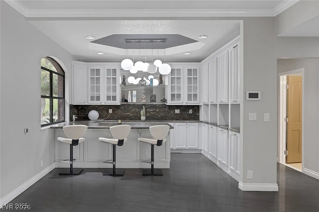 9 Quail Run Road Henderson, NV 89014 - Photo 13 of 57 A contemporary kitchen features an inviting breakfast bar with sleek pendant lighting.