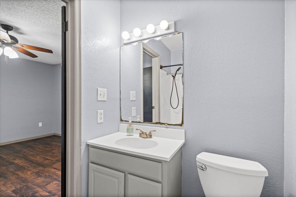 650 West Austin Street Luling, TX 78648 - Photo 12 of 18 A compact bathroom with vanity, toilet, and shower in a practical layout.