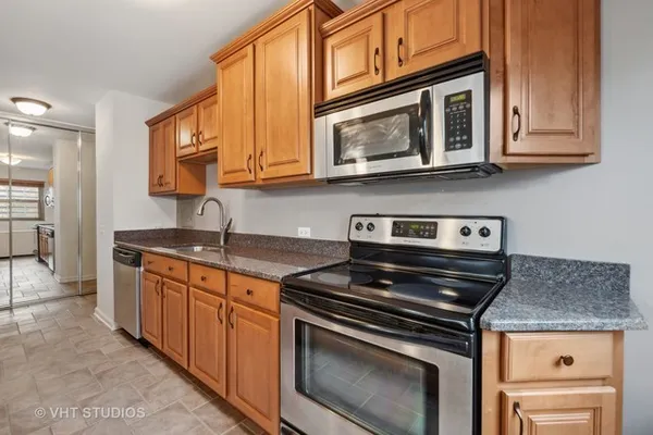 a kitchen with stainless steel appliances granite countertop a stove microwave and cabinets
