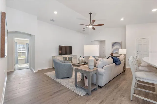 a living room with furniture and a wooden floor