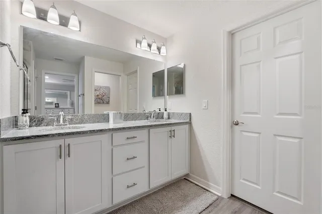 a bathroom with double sink and a mirror