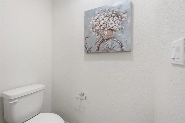 a white toilet sitting next to a white wall