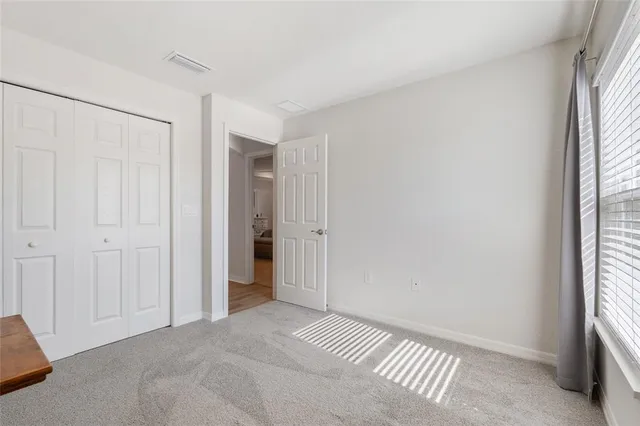 a view of a room with a ceiling fan and window