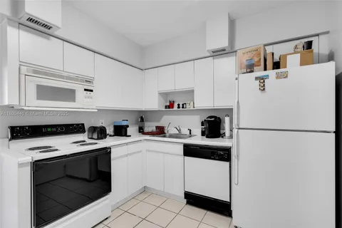 a kitchen with white cabinets and white appliances