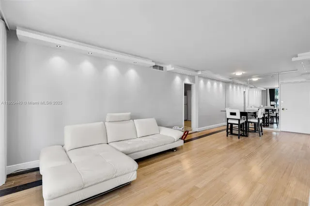 a living room with furniture and a dining table with kitchen view