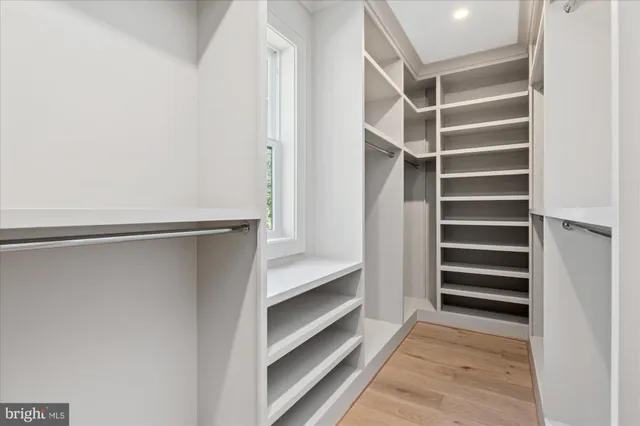 a view of an empty room with wooden floor and a fireplace