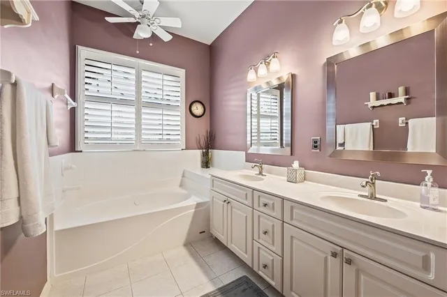 a bathroom with a tub sink and mirror