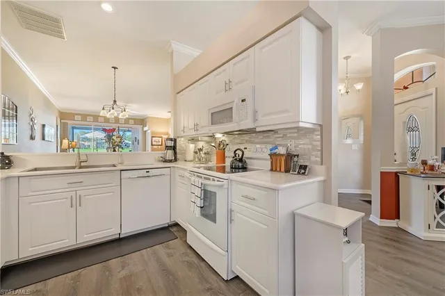 a kitchen with white cabinets and white appliances