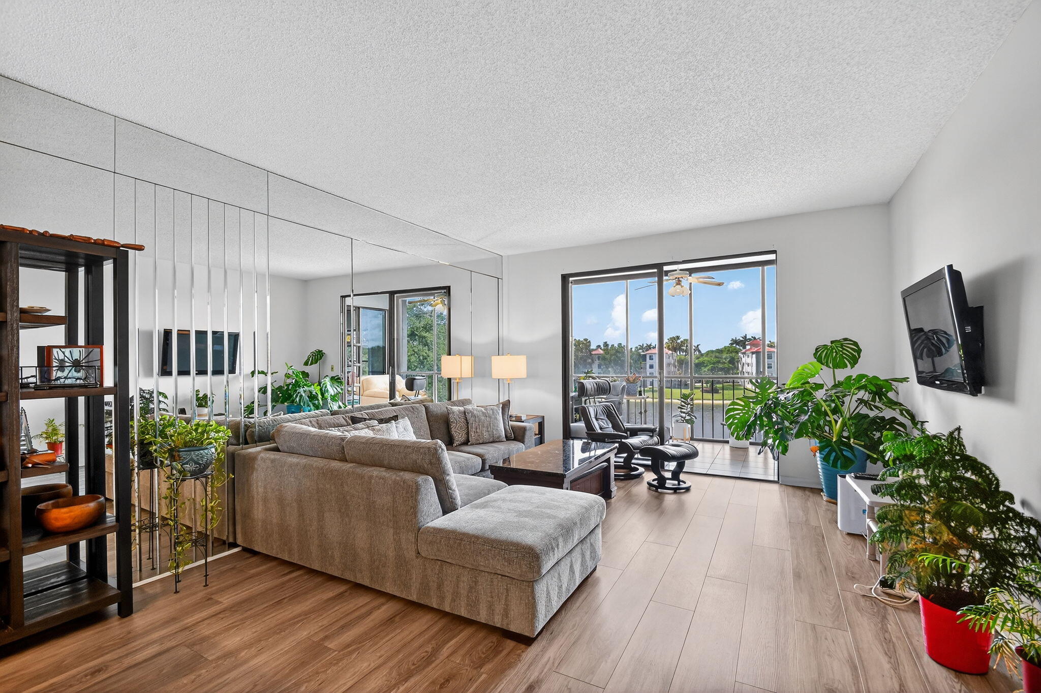 6193 Pointe Regal Circle, Unit 402 Delray Beach, FL 33484 - Photo 15 of 104 a living room with furniture potted plant floor and a flat screen tv