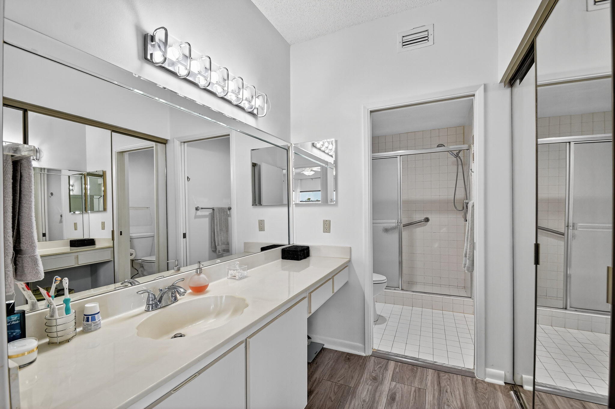 6193 Pointe Regal Circle, Unit 402 Delray Beach, FL 33484 - Photo 25 of 104 a bathroom with a sink a mirror a vanity and shower