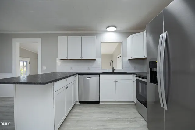 a kitchen with stainless steel appliances granite countertop a refrigerator sink and cabinets